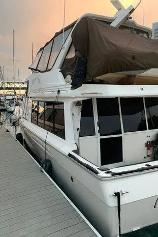 Slide: The Image of 1996 Bayliner 4788 yacht docked at sunset, featuring a spacious cabin and sleek design. - 5
