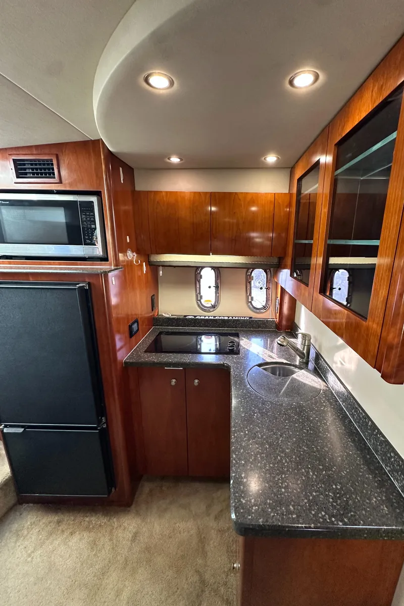Slide: The Image of 2007 Cruisers 390 Sport Coupe kitchen with wood cabinets, black countertops, and stainless steel sink. - 22