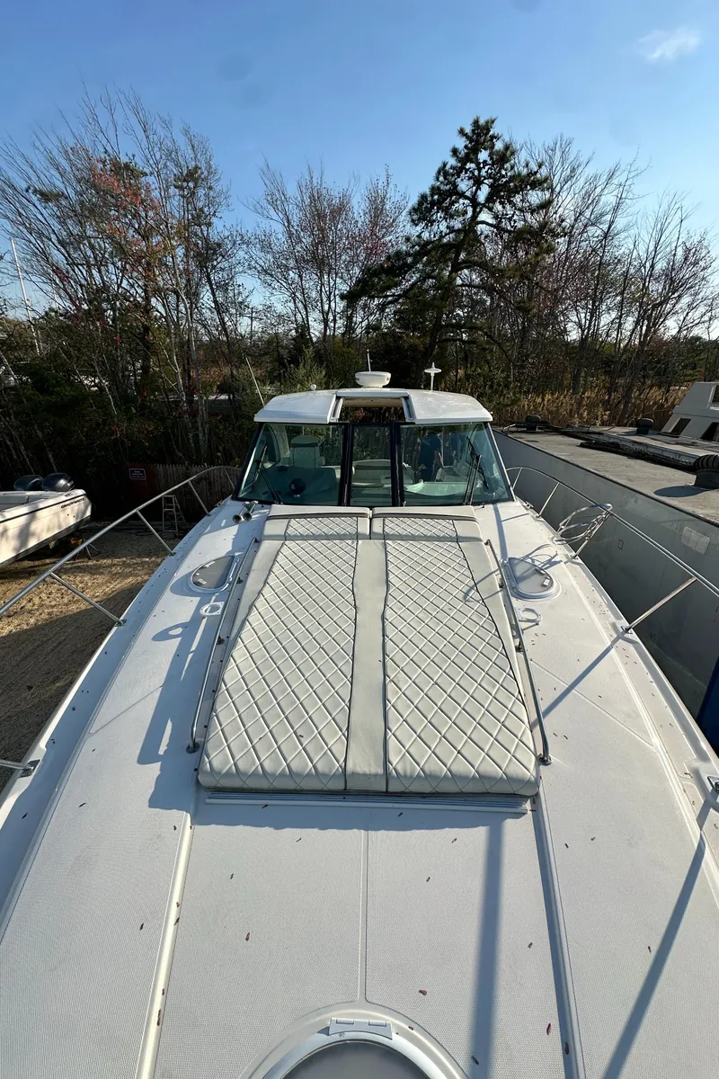 Slide: The Image of 2007 Cruisers 390 Sport Coupe boat on land, surrounded by trees under a clear sky. - 27