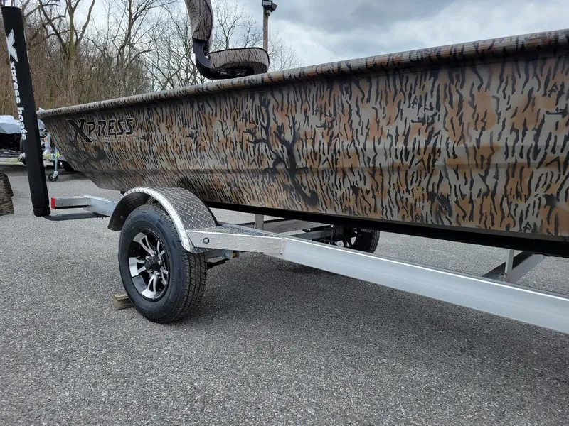 Slide: The Image of 2026 Xpress HD16DB duck hunting boat on trailer, camo design, awaiting Yamaha 50 hp engine. - 6