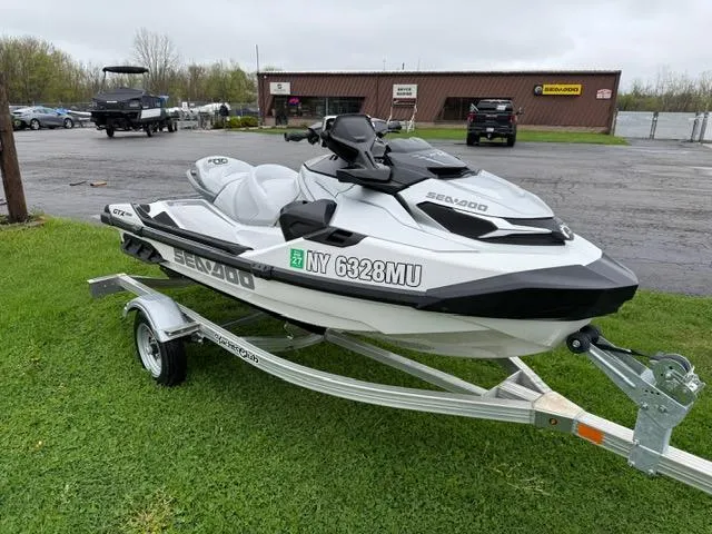 Slide: The Image of 2024 Sea-Doo GTX Limited 300 White Pearl Premium on trailer, parked on grass. - 4