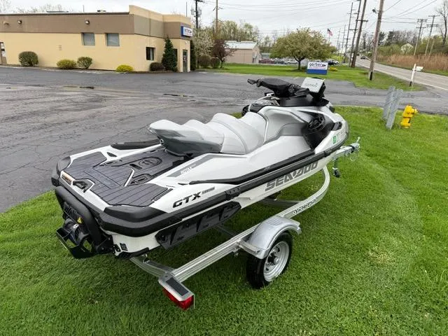 Slide: The Image of 2024 Sea-Doo GTX Limited 300 White Pearl Premium on trailer, parked on grass. - 5