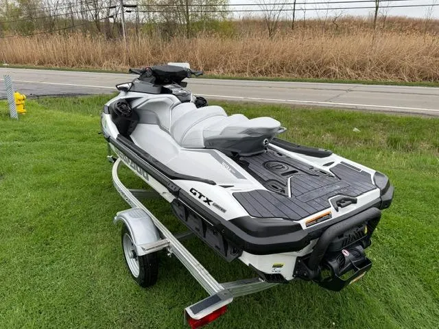 Slide: The Image of 2024 Sea-Doo GTX Limited 300 White Pearl Premium on trailer, parked on grass. - 6