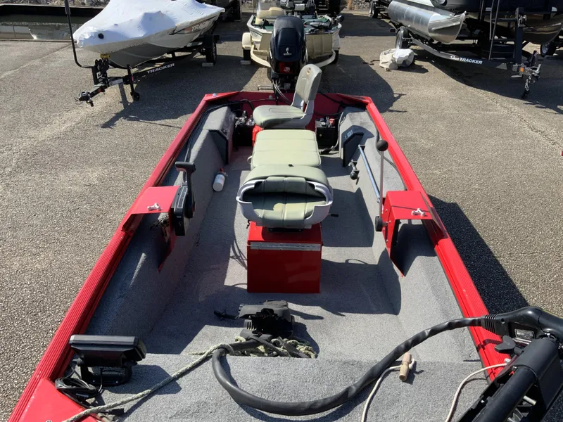 Slide: The Image of 2006 Triton 1546 SS boat with red interior, parked in a marina. - 4