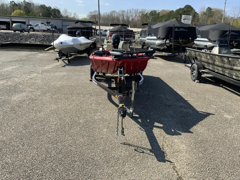 Slide: The Image of 2006 Triton 1546 SS boat on trailer in outdoor lot, surrounded by other boats. - 5