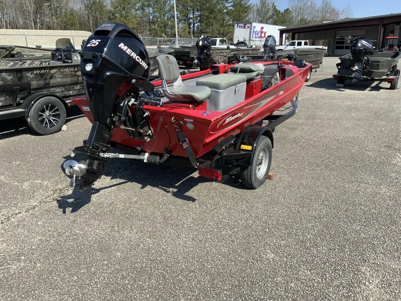Slide: The Image of Red 2006 Triton 1546 SS boat with Mercury 25 engine, parked outdoors. - 8