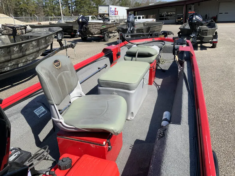 Slide: The Image of 2006 Triton 1546 SS boat with seating and storage, parked outdoors. - 9