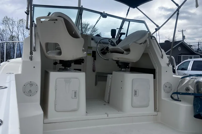 Slide: The Image of 1999 Parker 21 Cuddy Cabin boat interior with dual seats and steering wheel. - 6