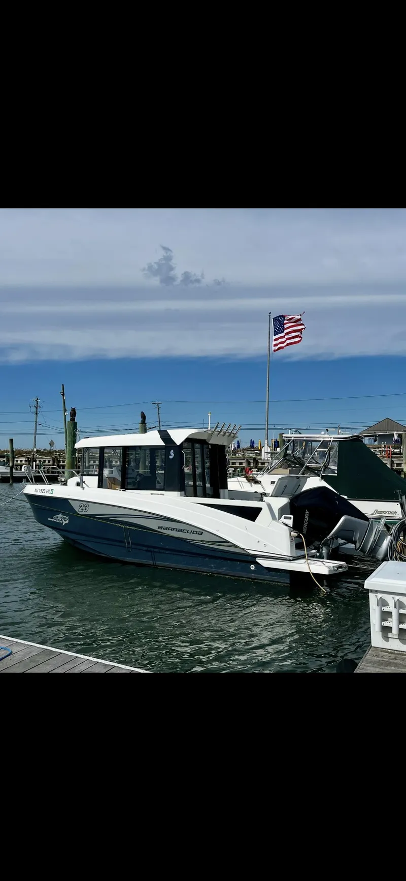 Slide: The Image of 2020 Beneteau Barracuda 8 boat docked, American flag in background. - 1