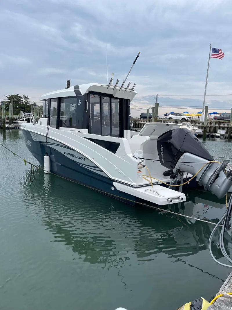 Slide: The Image of 2020 Beneteau BARRACUDA 8 boat docked in marina with American flag. - 13