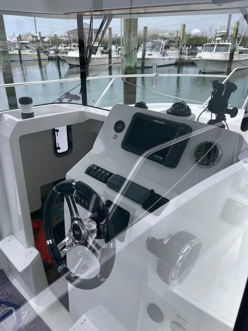 Slide: The Image of Interior view of 2020 Beneteau BARRACUDA 8 boat cockpit with steering wheel and controls. - 29
