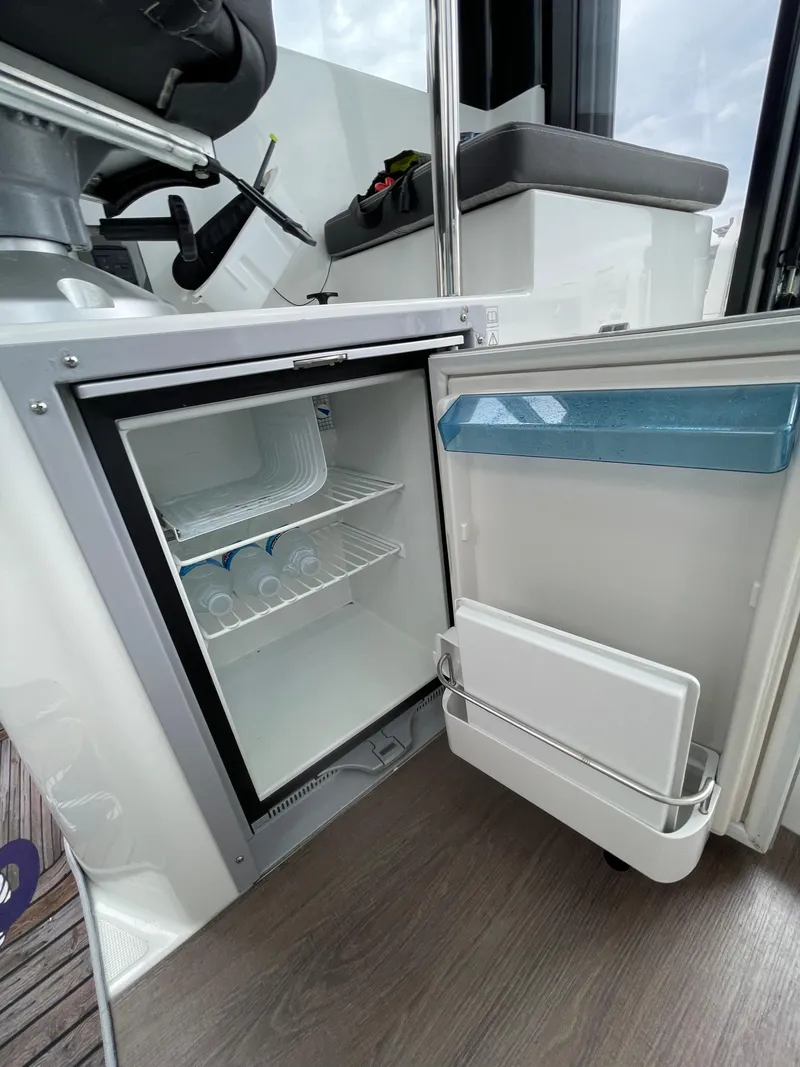 Slide: The Image of Beneteau Barracuda 8 (2020) boat interior with open mini fridge, showcasing storage space. - 46