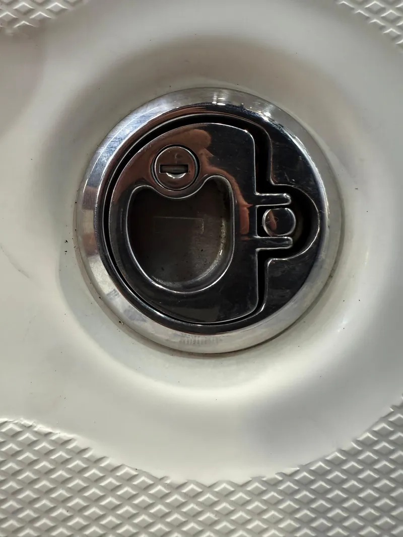 Slide: The Image of Chrome latch on 2020 Mako 21 LTS boat deck, featuring textured surface. - 14