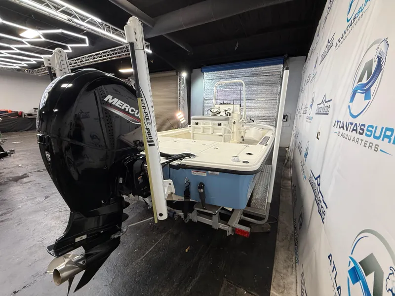 Slide: The Image of 2020 Mako 21 LTS boat with Guide Package, featuring a Mercury engine, indoors. - 6