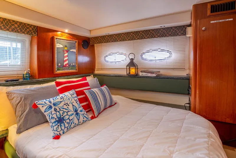 Slide: The Image of Interior of 2000 Carver 356 Aft Cabin Yacht with nautical-themed pillows on a beige sofa. - 21