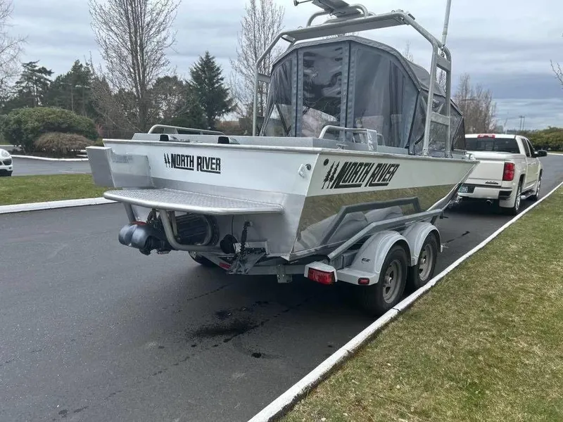 Slide: The Image of 2013 North River Commander boat on trailer, parked on a paved road. - 3