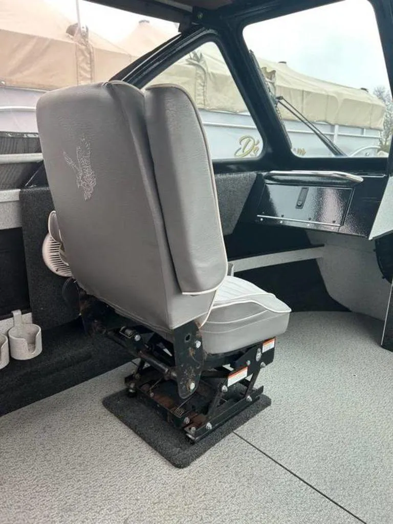 Slide: The Image of Interior of a 2013 North River Commander boat featuring a cushioned captain's chair. - 7