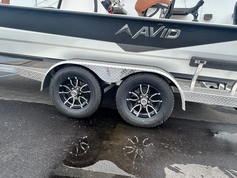 Slide: The Image of Avid 22 Recon 2025 boat on a dual-axle trailer with black alloy wheels. - 11