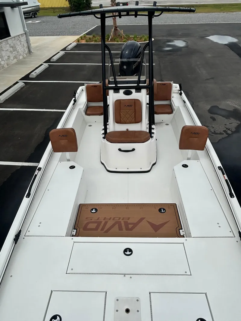 Slide: The Image of Avid 22 Recon 2025 boat with brown seating and sleek white deck design. - 12