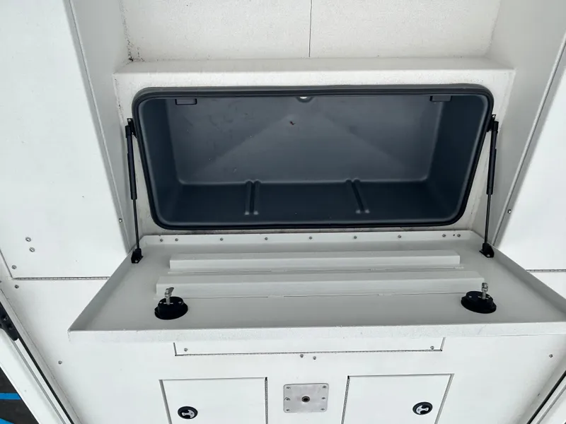 Slide: The Image of Open storage compartment in 2025 Avid 22 Recon vehicle interior. - 9