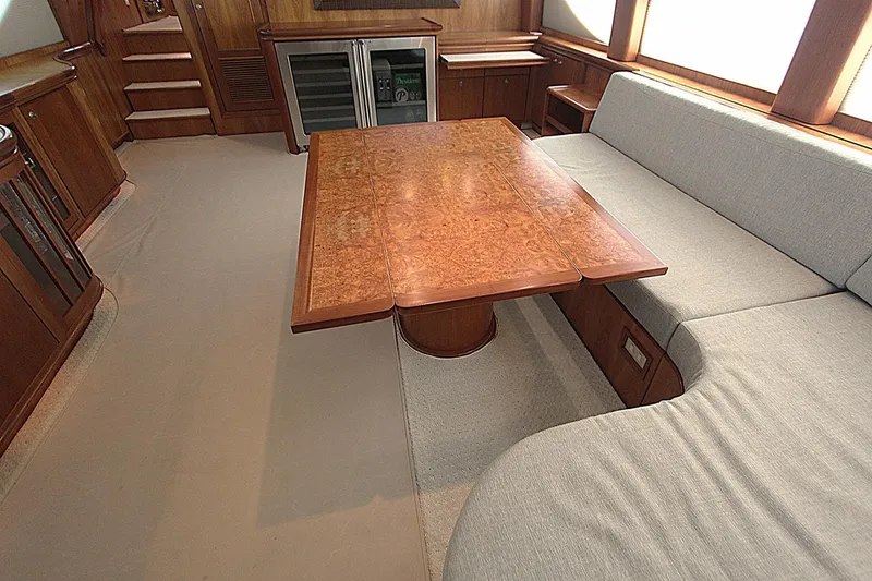 Slide: The Image of Luxurious interior of 2001 Symbol 62 Pilothouse yacht with wooden table and plush seating. - 10