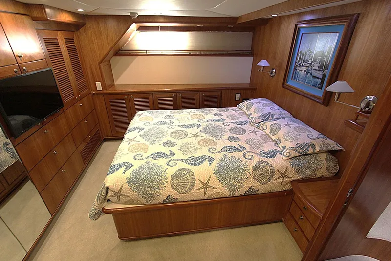 Slide: The Image of Luxurious bedroom in 2001 Symbol 62 Pilothouse yacht with elegant wood paneling and cozy bedding. - 16