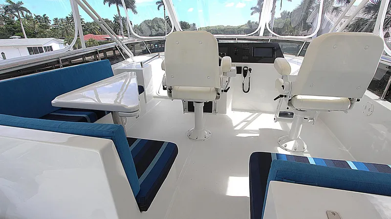 Slide: The Image of Luxurious 2001 Symbol 62 Pilothouse interior with seating and helm, featuring blue accents. - 21
