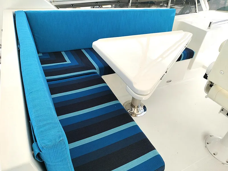Slide: The Image of Blue and black striped seating with a triangular table on a 2001 Symbol 62 Pilothouse yacht. - 23