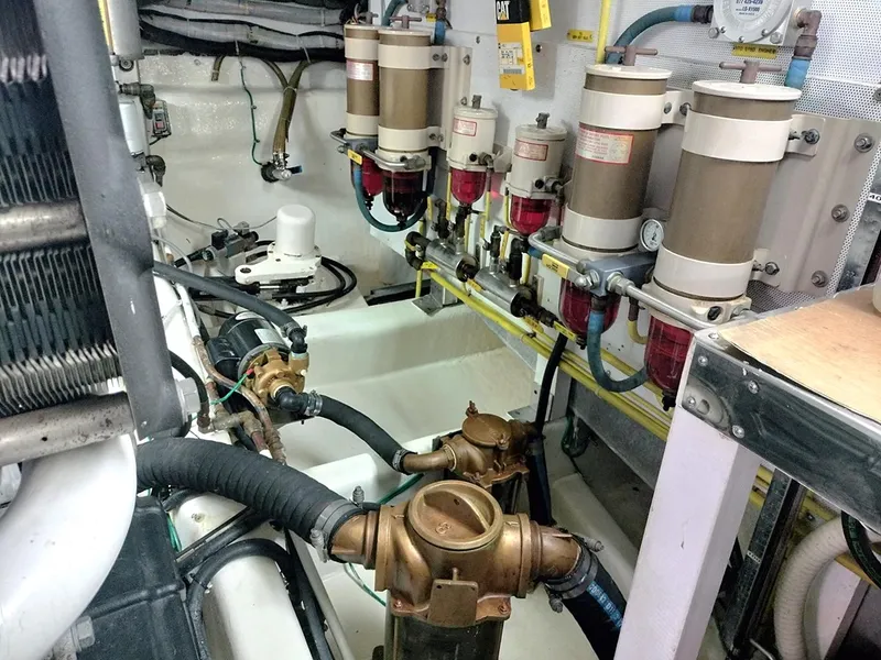 Slide: The Image of Engine room of a 2001 Symbol 62 Pilothouse with fuel filters and piping. - 28