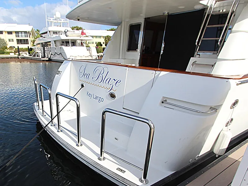 Slide: The Image of 2001 Symbol 62 Pilothouse yacht docked, featuring "Sea Blaze" and "Key Largo" on the stern. - 3