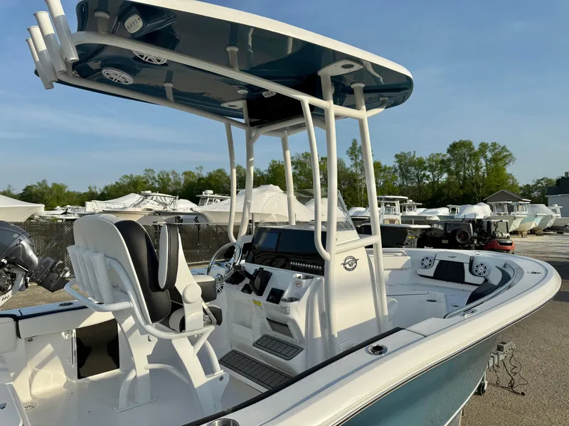 Slide: The Image of 2025 Tidewater 210 LXF boat with T-top and dual seating, docked outdoors. - 18