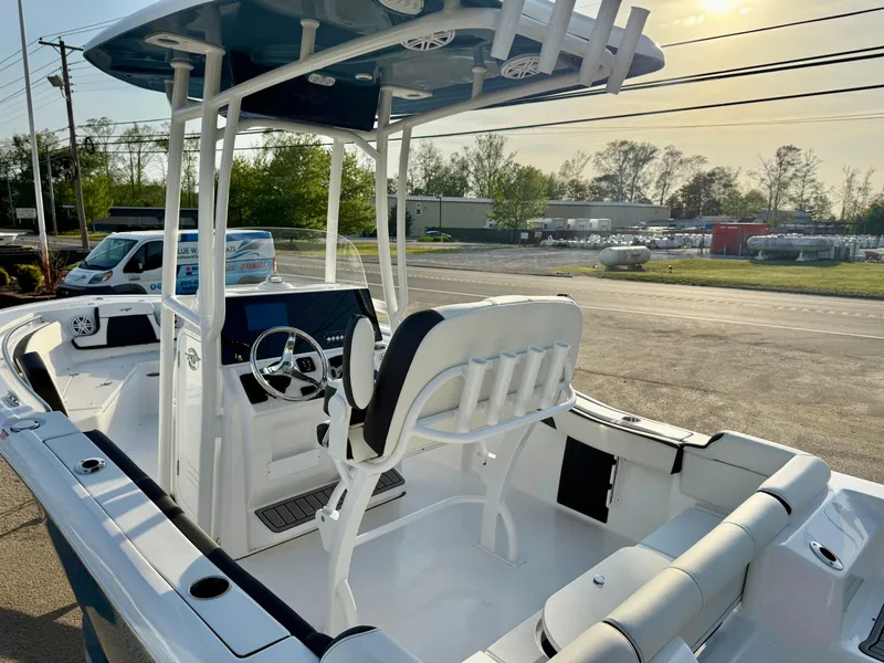 Slide: The Image of 2025 Tidewater 210 LXF boat with modern seating and steering, parked outdoors. - 9
