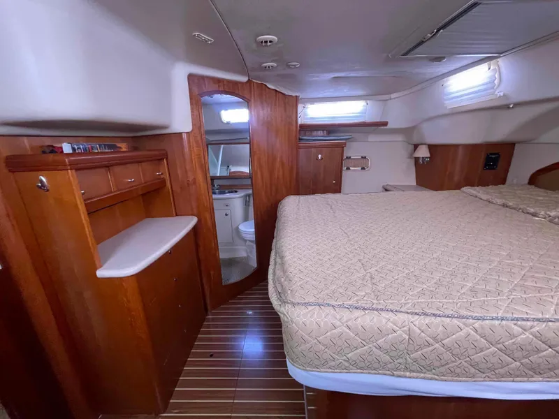 Slide: The Image of Interior of 2006 Hunter 45 Center Cockpit yacht, featuring a cozy bedroom and wooden cabinetry. - 19