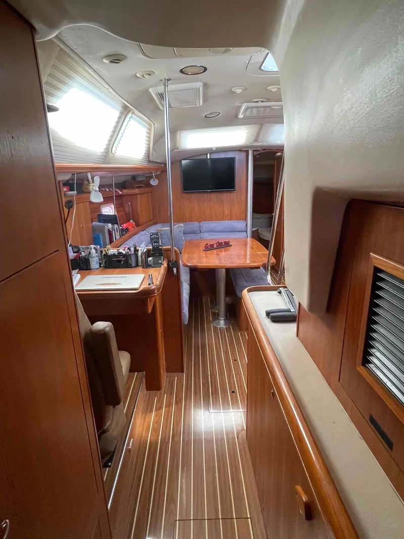 Slide: The Image of 2006 Hunter 45 Center Cockpit interior with wood finish, dining area, and navigation station. - 23