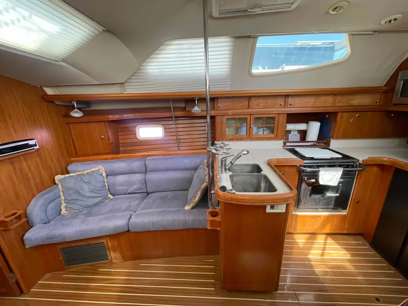 Slide: The Image of Interior of 2006 Hunter 45 Center Cockpit yacht with wood finish and cozy seating area. - 24