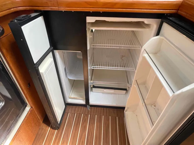 Slide: The Image of Open refrigerator in 2006 Hunter 45 Center Cockpit yacht, showcasing spacious interior and wooden flooring. - 28