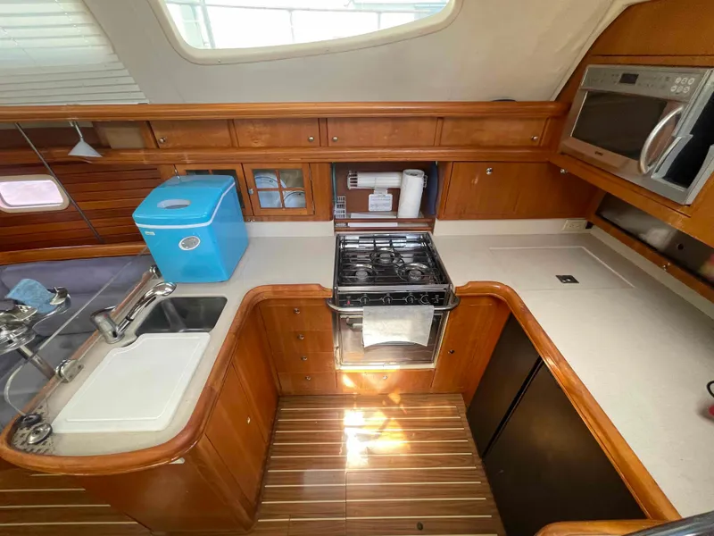 Slide: The Image of Interior of 2006 Hunter 45 Center Cockpit yacht kitchen with stove, sink, and microwave. - 3