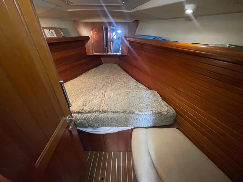 Slide: The Image of Cozy cabin interior of 2006 Hunter 45 Center Cockpit sailboat with wooden paneling and bed. - 34