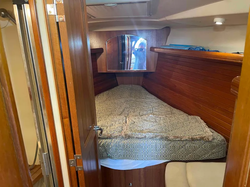 Slide: The Image of 2006 Hunter 45 Center Cockpit interior cabin with wooden paneling and cozy bed. - 35