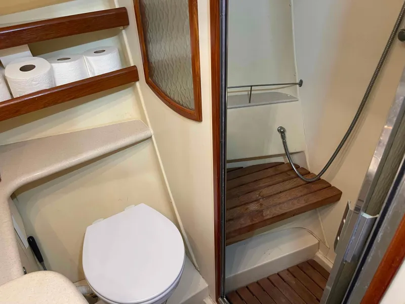Slide: The Image of 2006 Hunter 45 Center Cockpit bathroom with toilet, shower, and wooden accents. - 38