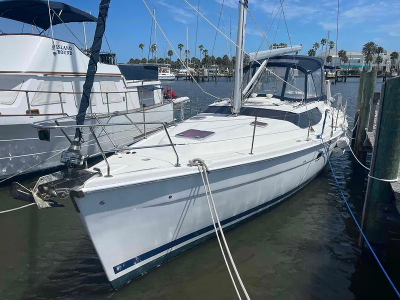 Slide: The Image of 2006 Hunter 45 Center Cockpit sailboat docked in a marina under a clear blue sky. - 39