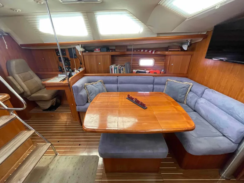 Slide: The Image of Interior of 2006 Hunter 45 Center Cockpit yacht with wooden table and blue seating. - 4