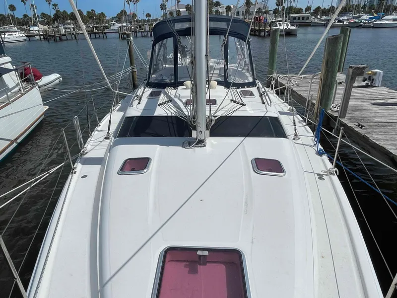 Slide: The Image of 2006 Hunter 45 Center Cockpit sailboat docked at marina, featuring spacious deck and cockpit. - 45