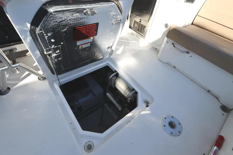 Slide: The Image of 2015 Cruisers Cantius boat storage compartment with open hatch and visible equipment. - 13