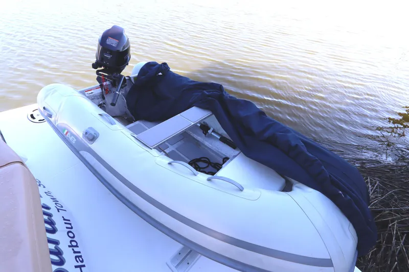 Slide: The Image of 2015 Cruisers Cantius with inflatable boat and outboard motor on calm water. - 17