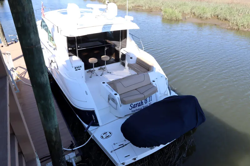 Slide: The Image of 2015 Cruisers Cantius yacht docked, featuring spacious deck and seating area. - 2