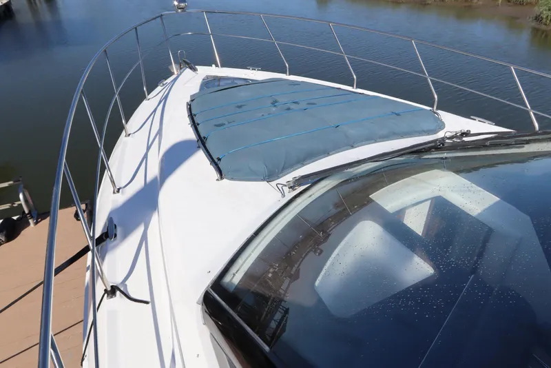 Slide: The Image of 2015 Cruisers Cantius yacht deck with blue cover, docked by calm water. - 20