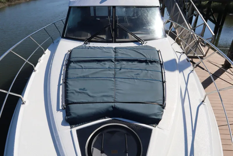 Slide: The Image of 2015 Cruisers Cantius boat with covered deck, docked by the water. - 22