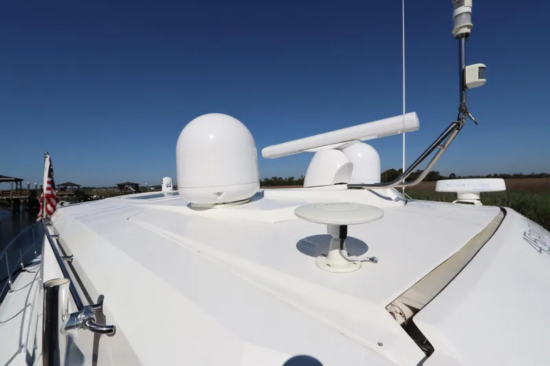 Slide: The Image of 2015 Cruisers Cantius yacht deck with radar and satellite equipment under clear blue sky. - 26