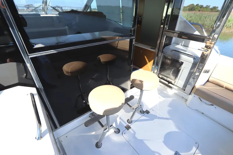 Slide: The Image of 2015 Cruisers Cantius boat interior with bar stools and glass doors. - 31